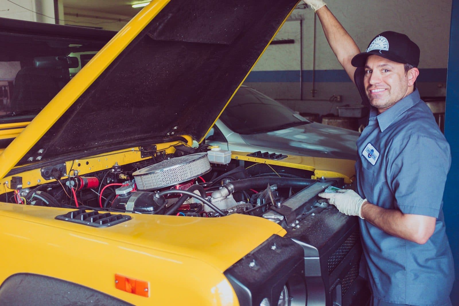 A mechanic at work over an engine bay, the early years of MIK Garage